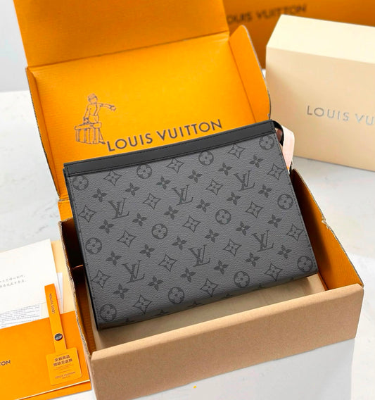 A Louis Vuitton monogram pouch in dark gray coated canvas, displayed inside its orange Louis Vuitton box alongside branded packaging and a cream-colored box.