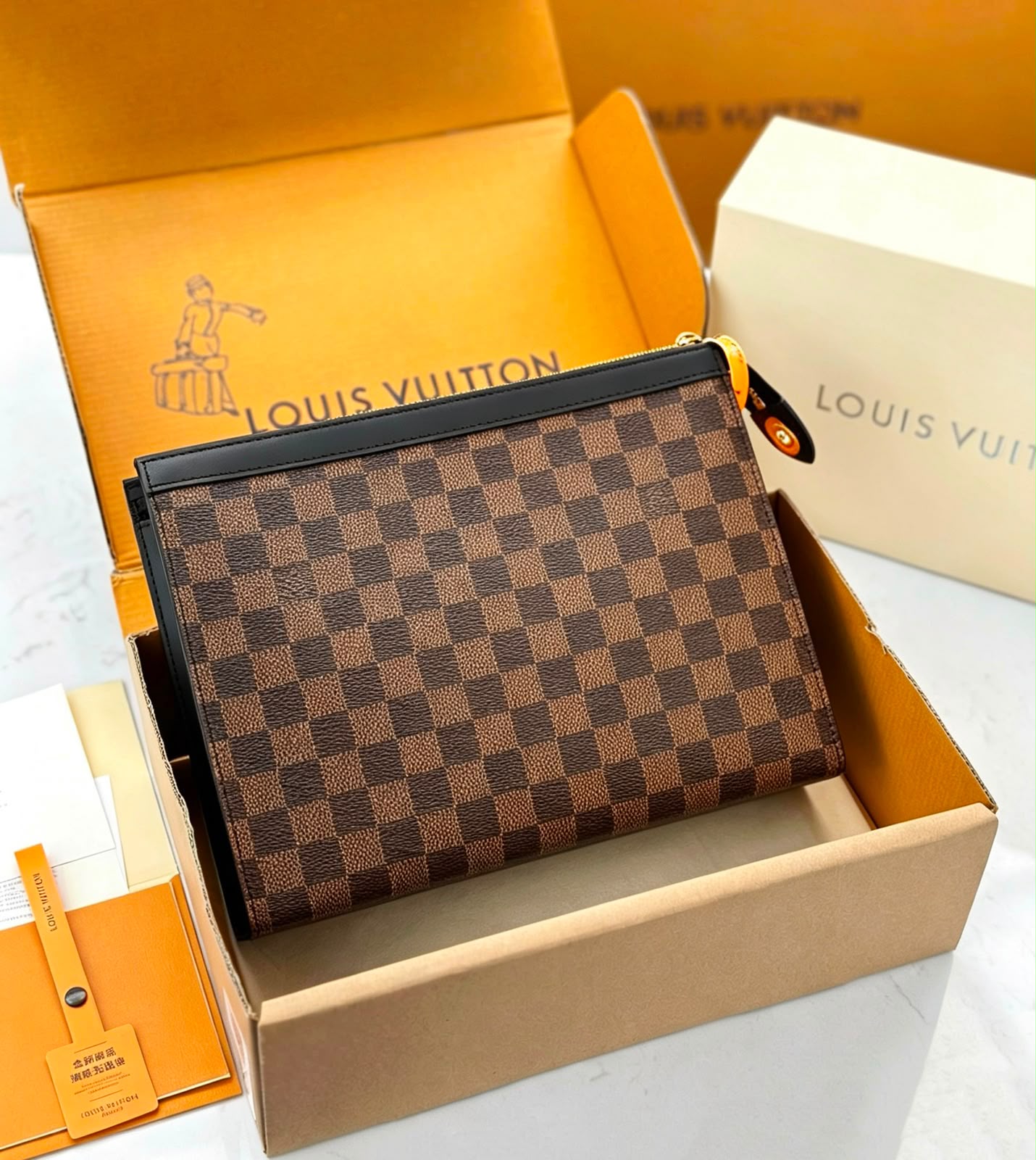 A Louis Vuitton zip-around wallet in the Damier Ebene checkered pattern, presented inside its open original Louis Vuitton box with orange and cream packaging visible.